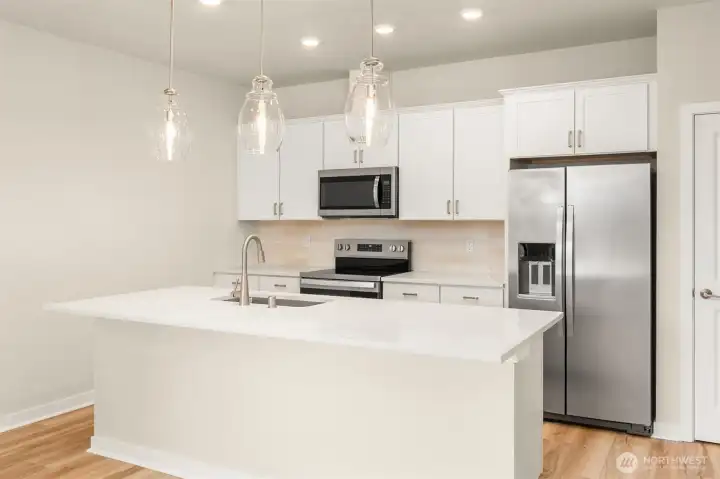 Kitchen is nice and bright with with overhead and pendant lighting