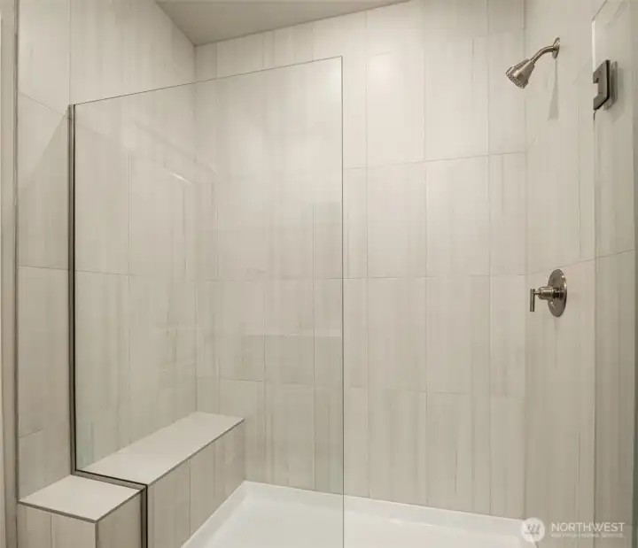 Frameless shower with floor to ceiling tile and bench