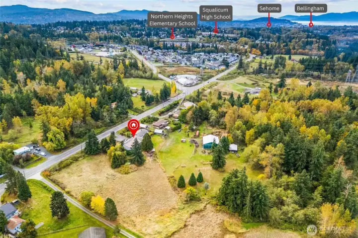 Aerial showing the property’s location amidst natural greenery and Hwy.
