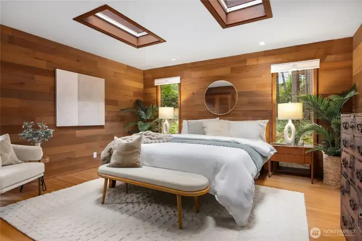 The Primary Bedroom is approximately 13'-8" X 14'8". flanked by more glass, new window coverings, hardwood floors and private bath.