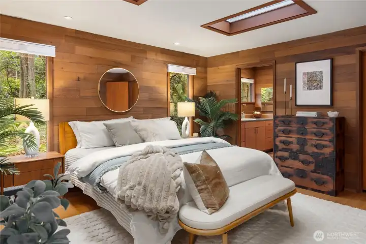 The primary bedroom has a walk -in closet, skylights and warm horizontal cedar walls.