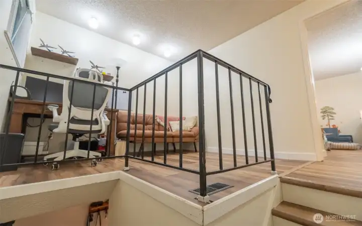 view heading up the stairs looking into the open den/office