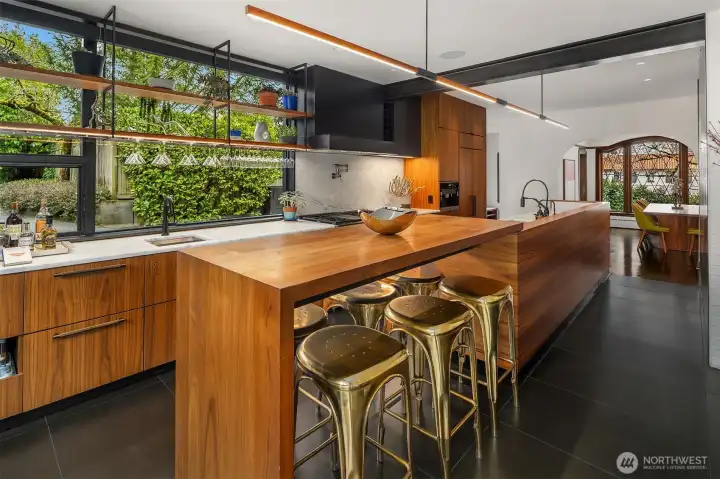 Rich wood, marble, dark metal flows from the original front of the home into the kitchen and living area