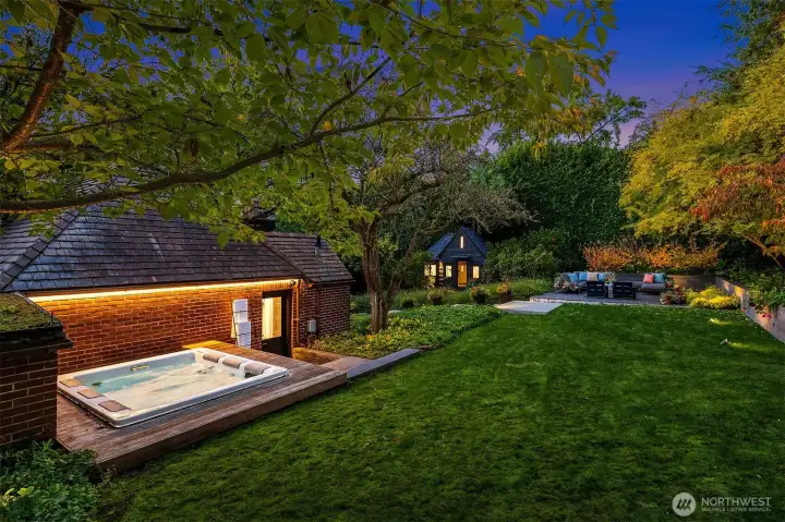 Hot tub tucked behind the garage and a flat grassy area for Fido, croquet, kid play