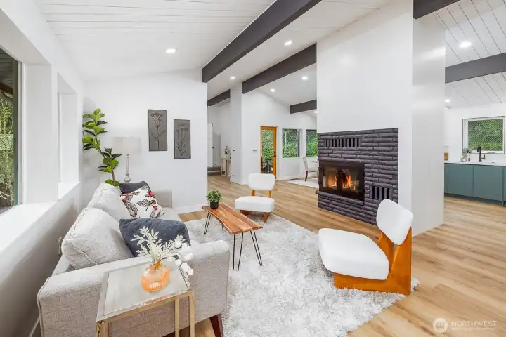 Step into your mid mod dream home! Anchored by the wood burning fireplace, this home is special!  Open and circular floor plan with wide and grand spaces, lots of natural and thoughtfully placed lighting.  Wide plank floors add a warm and very durable element to the space.