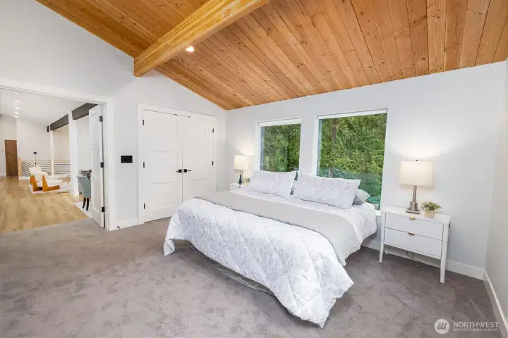 The primary bedroom is a true ensuite!  Just a few steps up from the main living space, this tranquil retreat is your own private getaway.  Serene and lush views outside your windows, high reaching wood ceilings and detailed dimable lighting throughout.