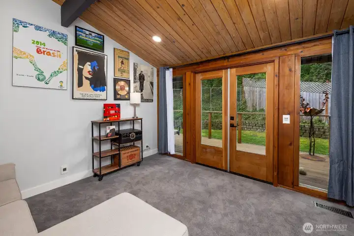 A view of the private deck and double doors leading out to the backyard in this fun and versatile room.