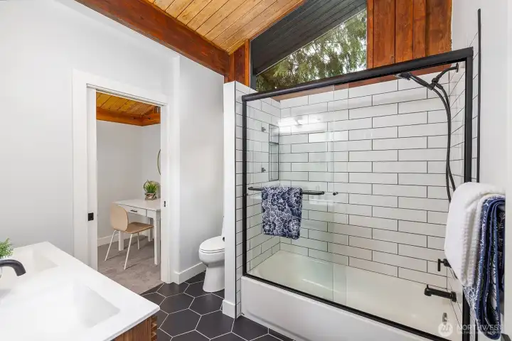 Second main floor full bathroom. Cool exposed wood ceilings, ,natural lighting and dual sink. This bathroom also acts as an ensuite to the very cool attached bedroom, or office space.