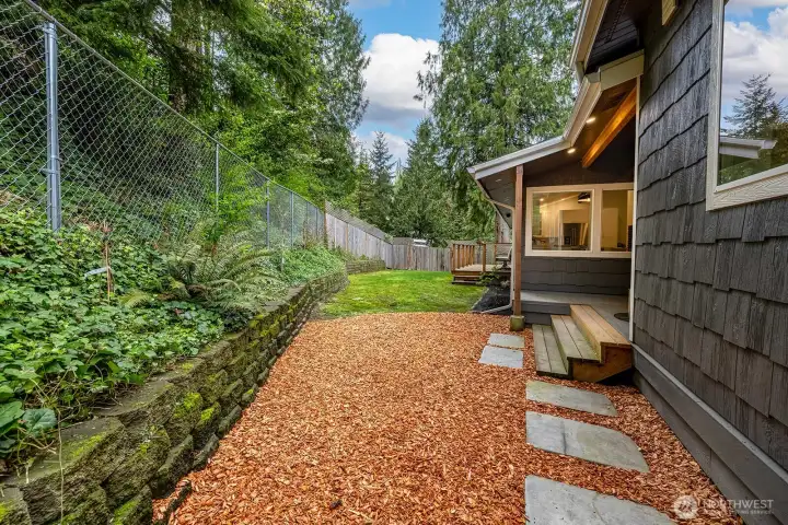 Side view of the yard are leading towards the south side of the home. Easy access via the walking steps.  Fully fenced for your four legged friends as well!