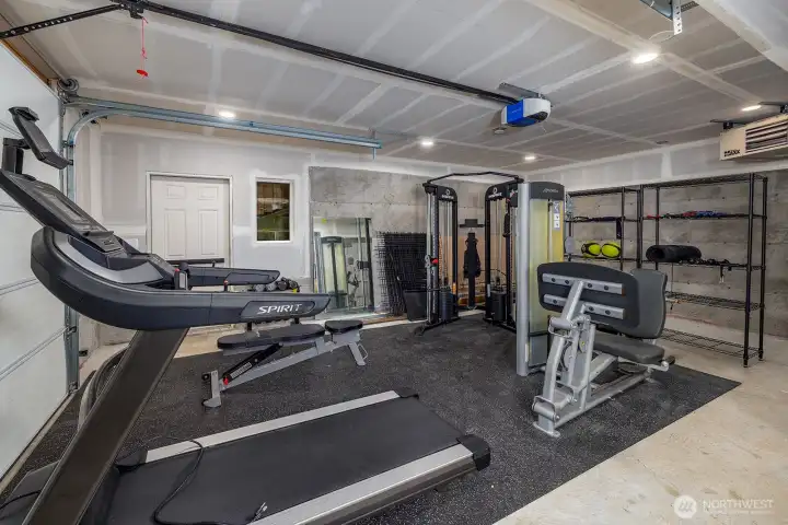 One of three, yes three garage bays!  This one is oversized, deep and tall and is outfitted with it's own heating system . Currently being used as a work out space.  Exterior man door for private access.