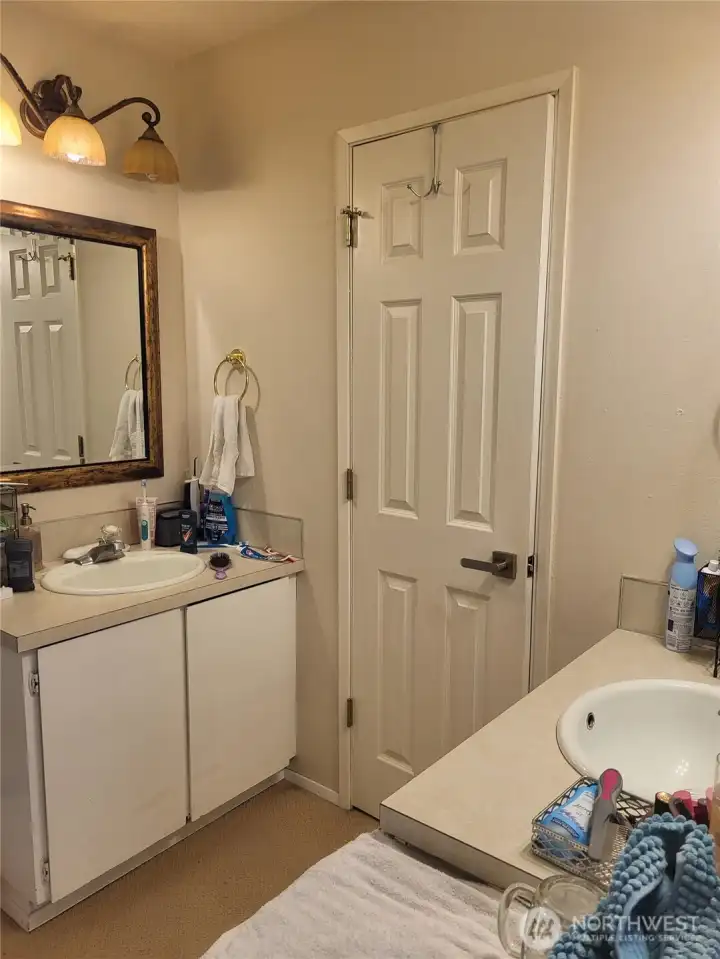 2nd Bathroom. There are two sinks with cupboards. One on each side, shower and toilet behind the door.