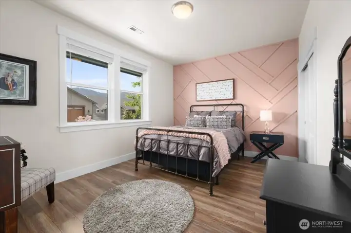Lower floor front bedroom featuring custom accent wall details, warm natural light, and flexible space for guests, office use, or everyday living.