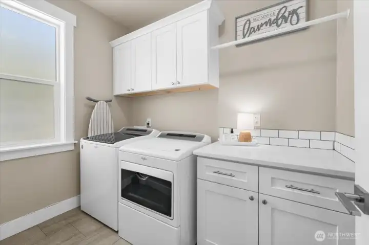 Conveniently located laundry room positioned near the primary suite with plenty of storage.
