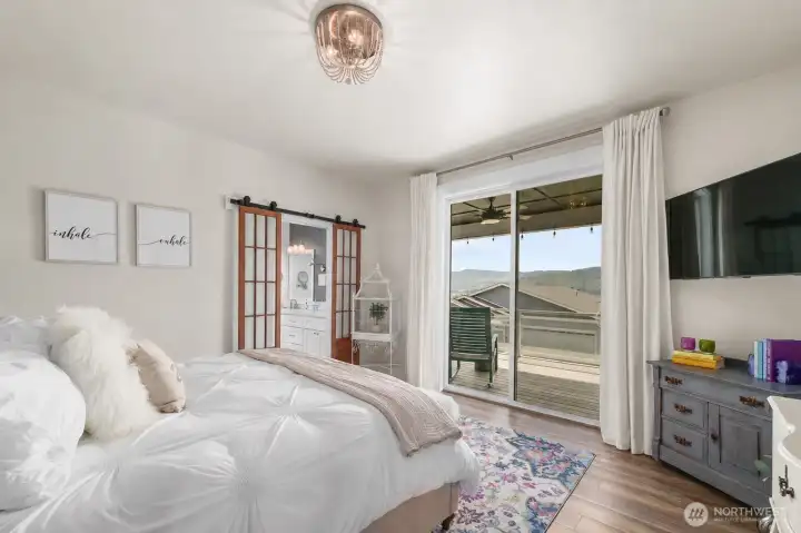 Primary suite designed to capture the surrounding views, with direct access to the deck for a seamless indoor-outdoor connection.