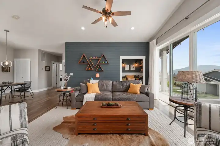 Warm and inviting gathering space with expansive sliding doors, surrounding views, and a cozy built-in nook tucked just off the main living area.