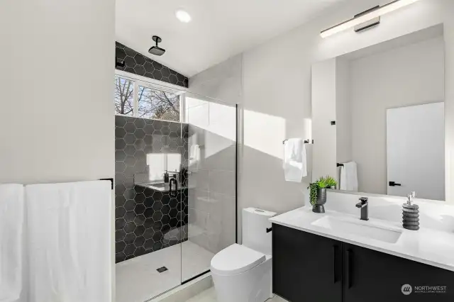 Elegance meets function in the bathroom, where black cabinets and matching tiles blend seamlessly for a chic, unified look.