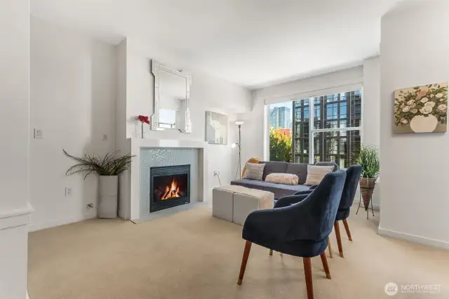 Bright and inviting—this spacious living room features a sleek tile-surround gas fireplace and floods with natural light in this top-floor, penthouse-style unit.