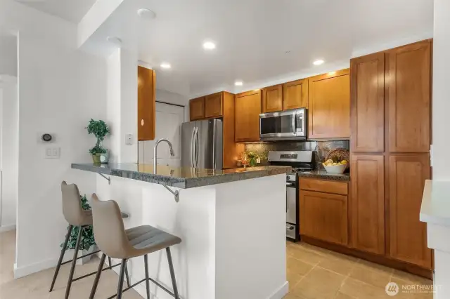 The open-concept kitchen offers stylish counter seating, perfect for casual dining or entertaining with ease.