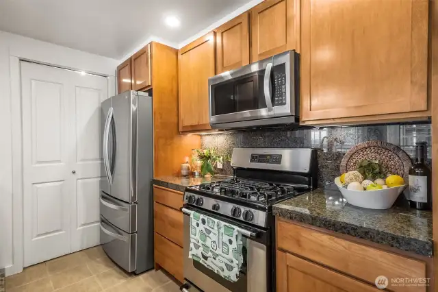 Timeless elegance. Granite countertops and backsplash pair seamlessly with stainless steel appliances for a polished, modern kitchen.