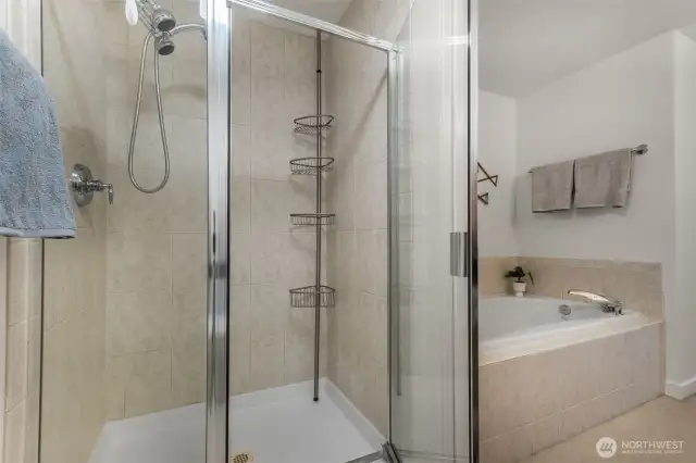 Spacious primary ensuite featuring a relaxing soaking tub, dual sinks, and refreshed vanity lighting for a bright, modern feel.