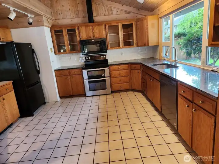 Large kitchen with granite counter and tile floor.