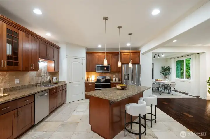 Central island for extra seating and prep space. Peek into the formal dining room beyond!