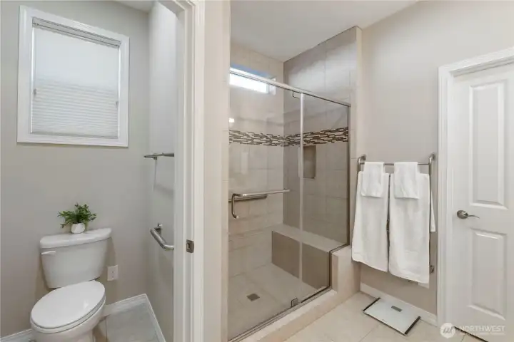 Primary bathroom with walk in shower, separate water closet with grab bars already installed.