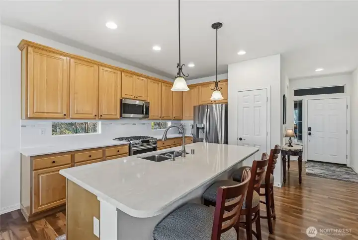 Island kitchen includes newer stainless steel appliances, quartz counter tops and subway tile backsplash.
