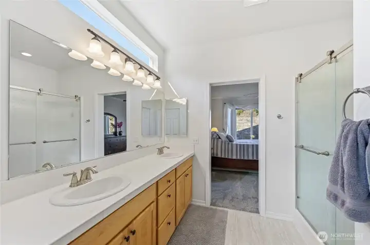 Primary bath with newer LVP flooring, faucets, light fixtures and chair height toilet.