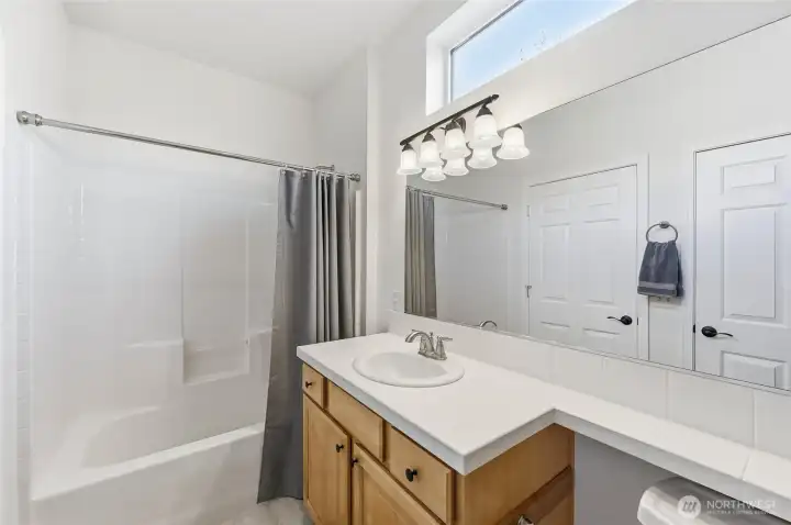 Full Guest bath with tile counter and new LVP    flooring and chair height toilet.