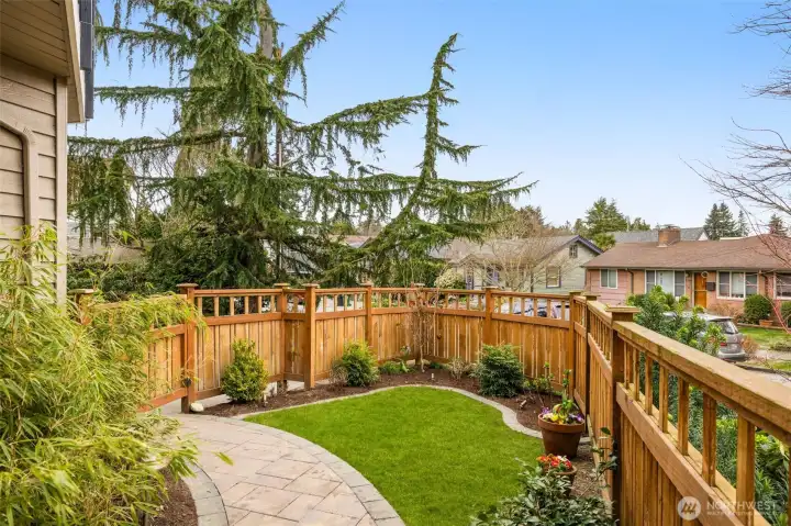 The east side yard leads to a lovely gardening and grassy area with a gate opening to the driveway.