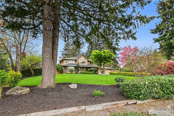 Surrounded by lush, mature landscaping and greenery.