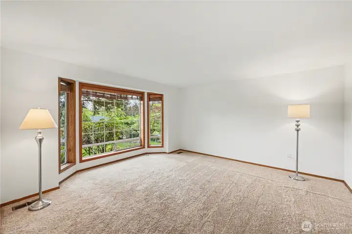 Living room positioned to the left of the entry, highlighted by expansive, light-filled windows.