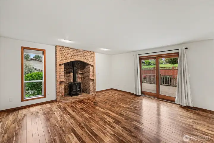 The living room features a freestanding gas fireplace set within a brick surround.