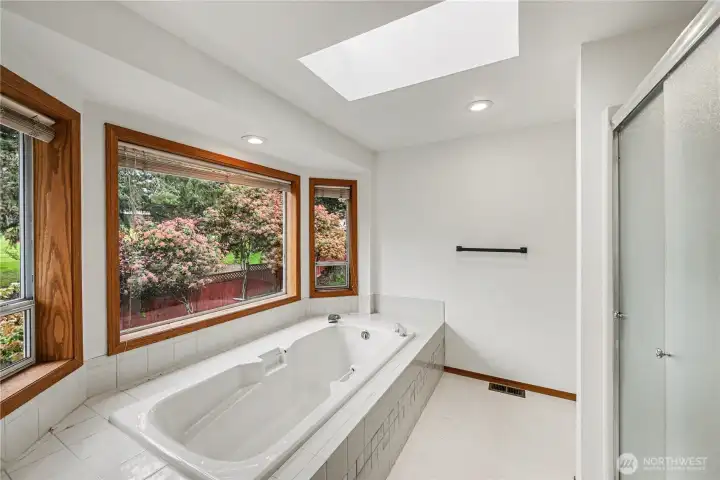 Unwind in the soaking tub beneath sunlit windows, with a skylight above and a separate shower for everyday convenience.
