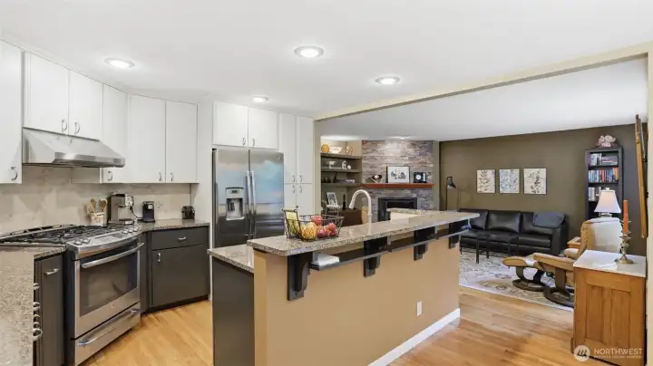 The kitchen has all stainless appliances with gas cooking, hardwood floors and a eating bar.