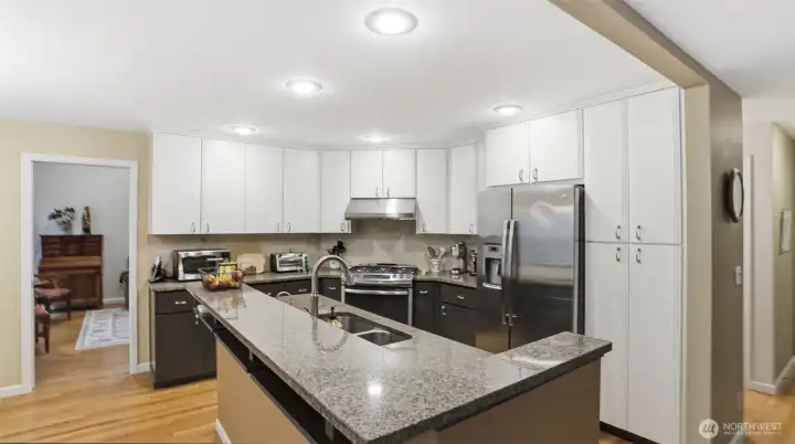 A different view of the kitchen with all of its' storage. Gorgeous granite counter tops surround the kitchen.