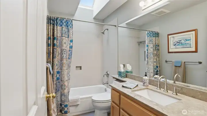Nice full hall bath with quartz counters and a bright skylight.