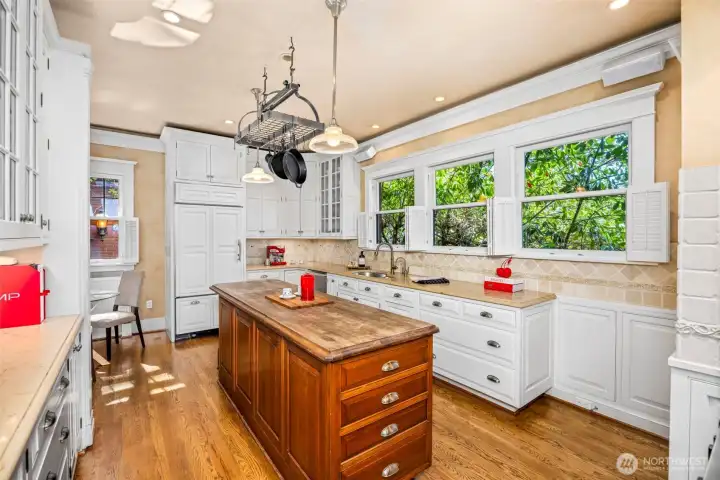 Framed by vibrant garden views, the sun-drenched sink wall makes daily meal prep a peaceful experience.