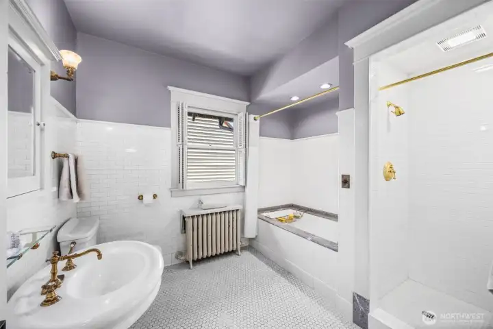 Vintage-inspired charm defines this light-filled bath, featuring timeless tilework and high-end brass fixtures.