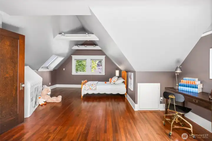 Nestled in the upper eaves, this whimsical and expansive bedroom offers a playful sanctuary filled with natural light.