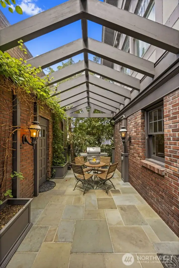 A secluded, timber-framed terrace creates an intimate, old-world setting for dining al fresco.