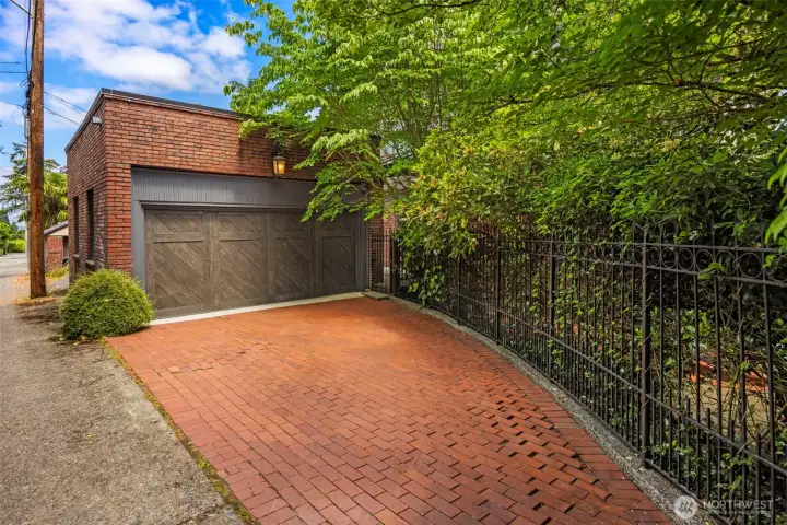 A handsome brick facade and custom wood-paneled door introduce the detached multi-car garage.