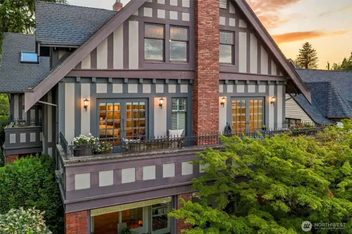 Architectural gables and second-story wrought-iron balconies capture the home's grand historical narrative at dusk.