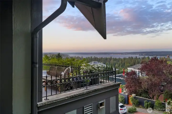 As evening falls, the terrace looks out over a sea of evergreens to the glistening waters beyond.