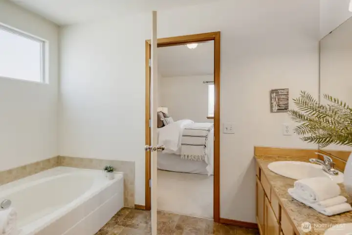 PLEASANT PRIMARY BATHROOM W/ SOAKING TUB IS CONVENIENT AND PRIVATE.