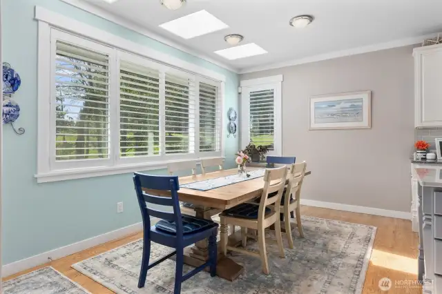 Light filled informal dining space with skylights and large windows overlooking the backyard and golf course.