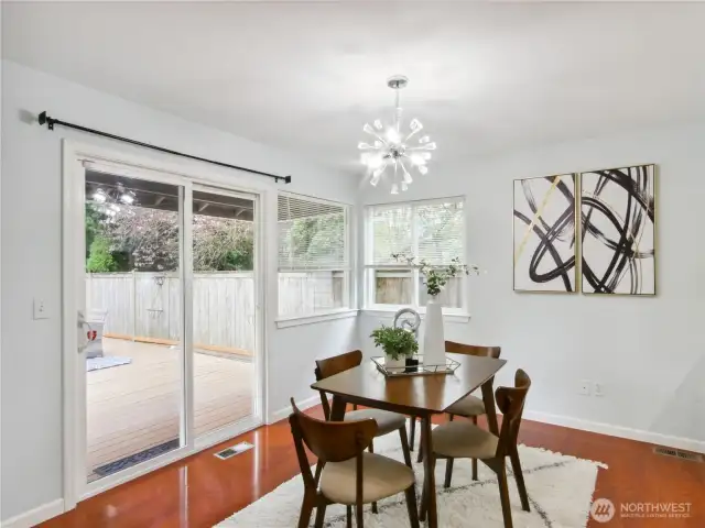 Elegant dining nook with pendant lighting and an open view of the backyard