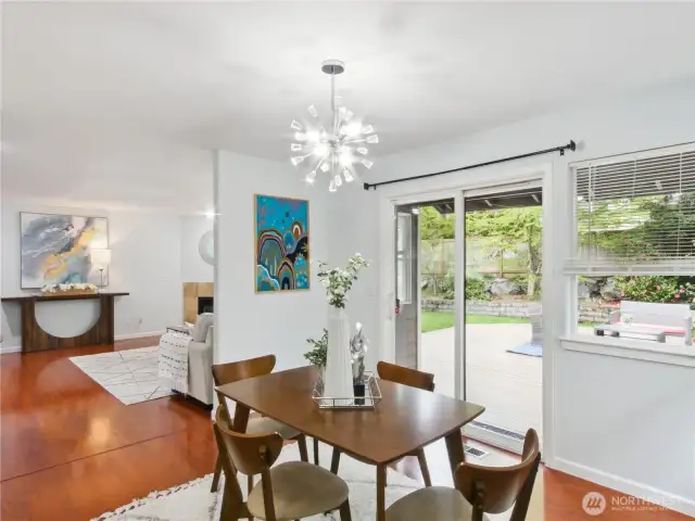 Elegant dining nook with pendant lighting and an open view of the backyard