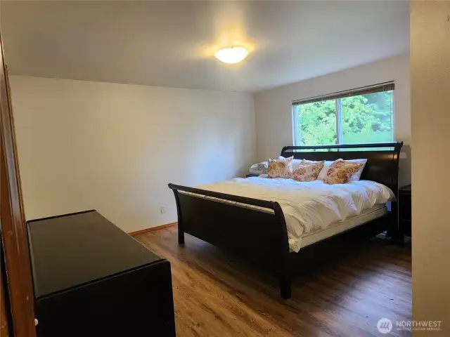 Main level Primary bedroom with en-suite. This is a king-size bed. Beautiful green belt behind property provides you with lots of privacy.